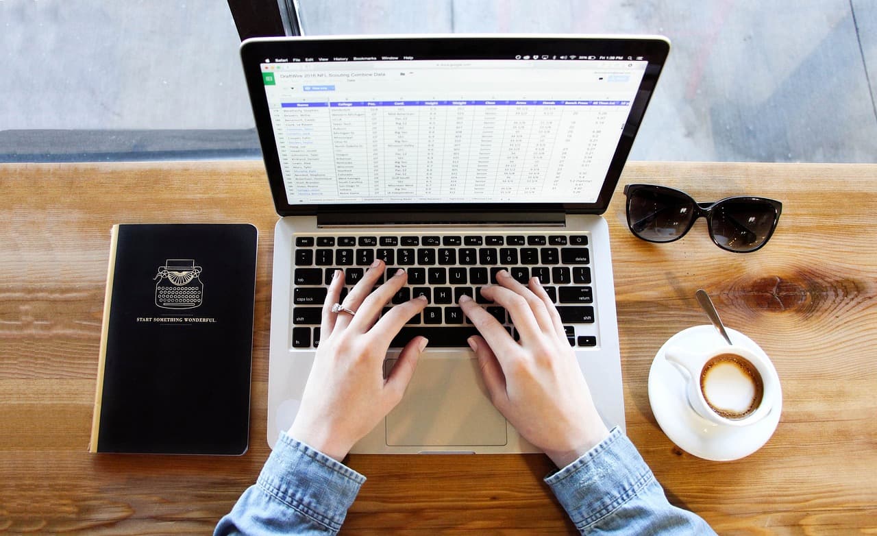 Working on a laptop at a desk with a coffee, the kind of setup a password manager runs on