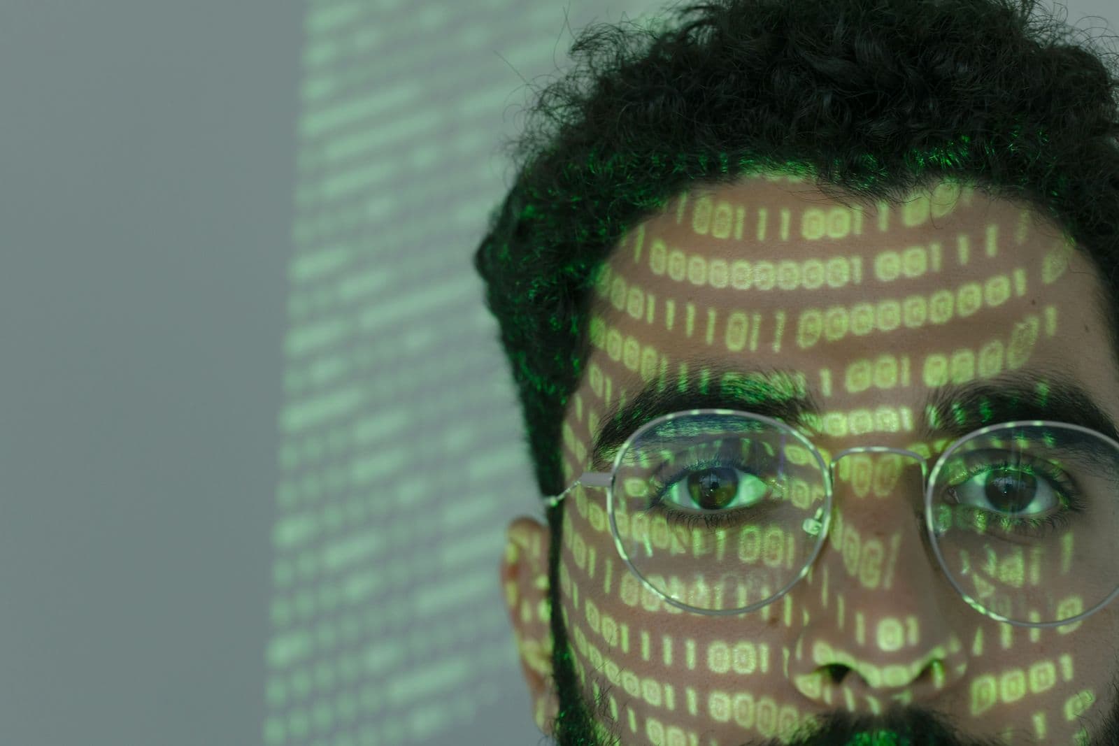 Das Gesicht eines Mannes, auf das Zeilen aus Binärcode projiziert werden