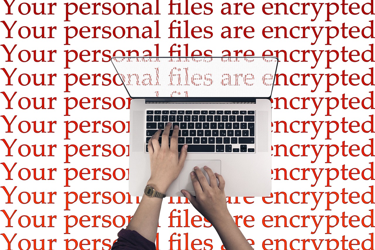 Manos escribiendo en un portátil con las palabras Tus archivos personales están cifrados repetidas en rojo - el tipo de nota de rescate que mostraría un ataque desde el navegador.