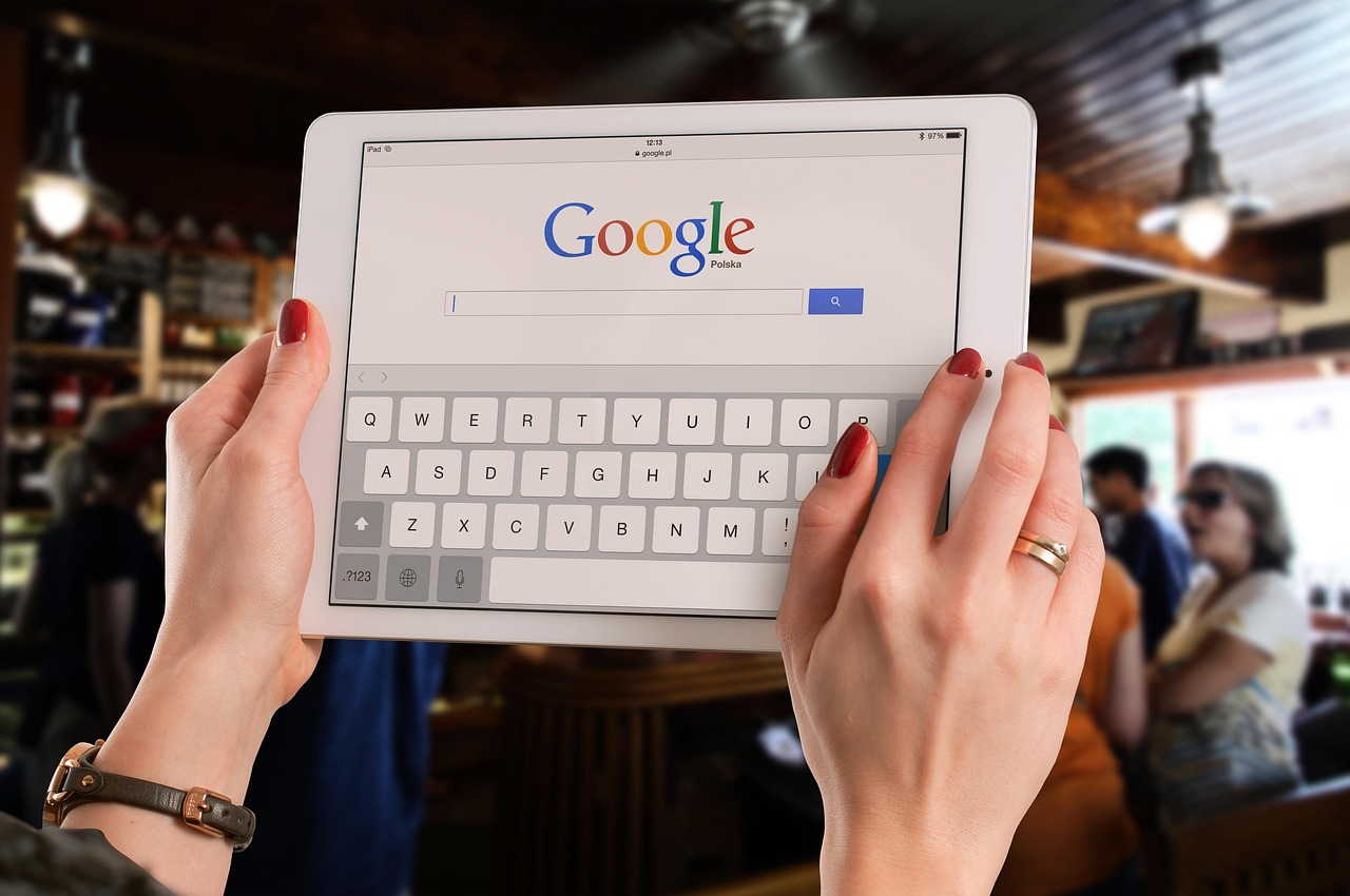 Manos sosteniendo una tableta abierta en la página de búsqueda de Google - Perplexity reinventa la búsqueda como respuestas directas con fuentes en vez de una lista de enlaces.